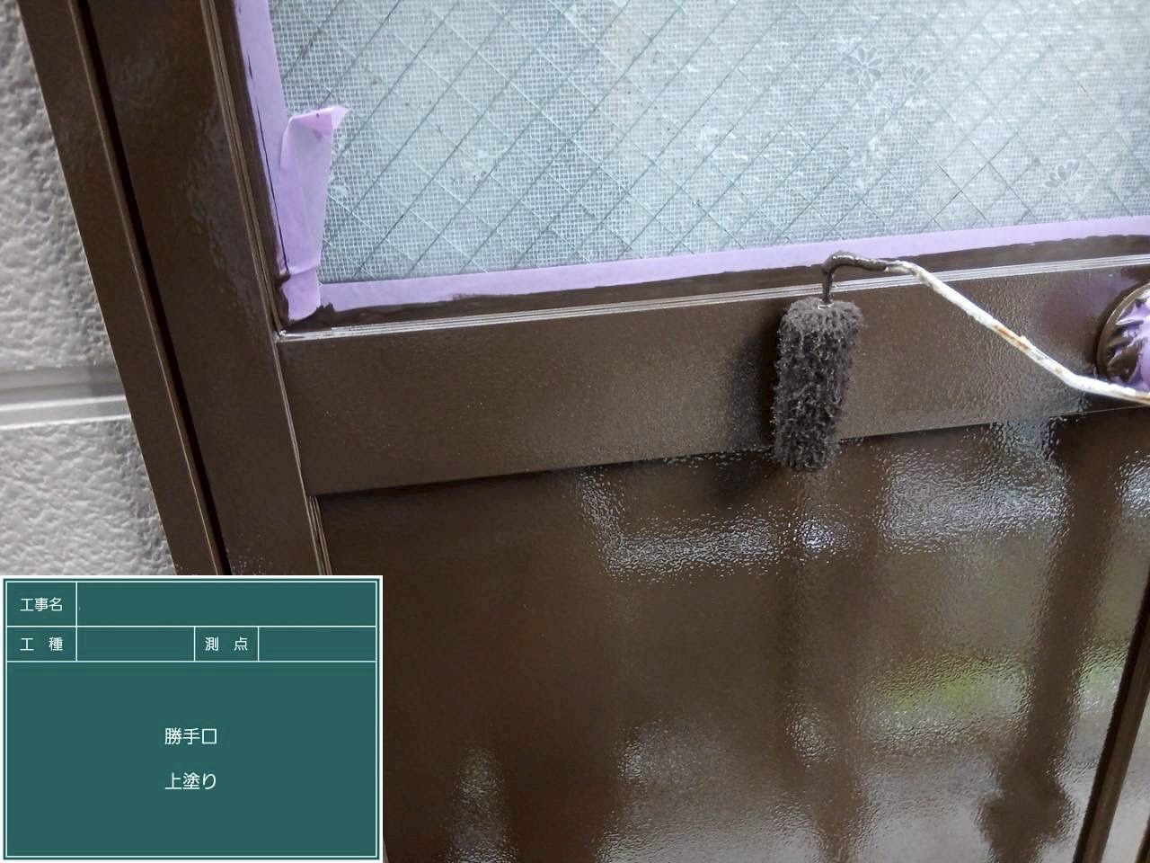 上塗りで塗料を塗り重ねている勝手口